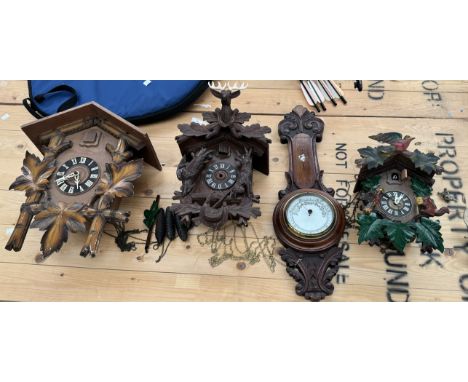 Three cuckoo clocks together with a barometer 