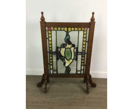 STAINED AND LEADED GLASS INSET FIRESCREEN,in a carved oak frame, 73cm wideA large amount of damage to the glass (additional i
