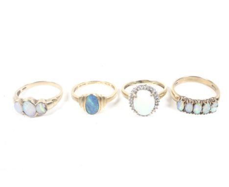 Four gold and opal rings including a 14ct gold and black-opal-doublet single stone ring. The oval stone rub-over set between 