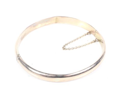 An Edwardian 9ct rose gold hollow hinged bangle. The domed band with hallmarks for Birmingham 1908, 7g