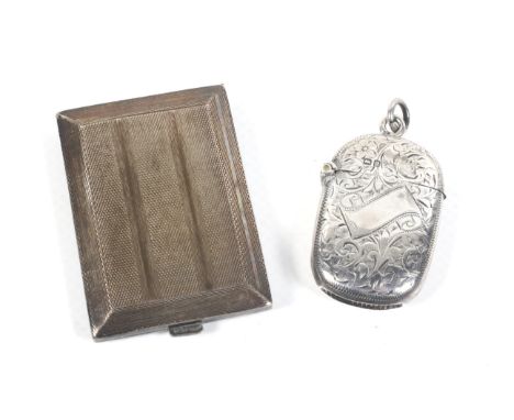 An Edwardian silver vesta/match case and a later silver match book cover. The vesta all-over engraved with foliate scrolls an