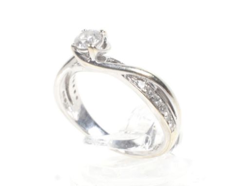 Forever Diamond, an 18ct white gold and diamond ring. Centred with a round brilliant diamond approx. 0.21cts, claw set betwee