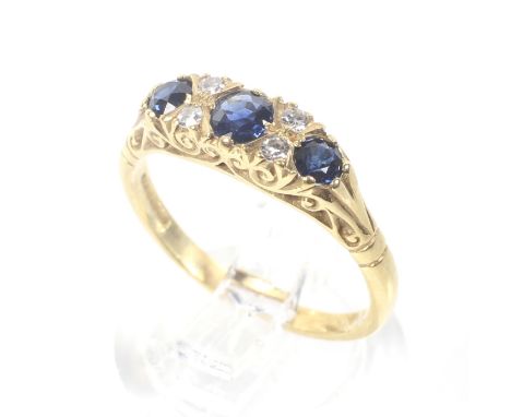 A vintage 18ct gold, sapphire and diamond cast carved half-hoop ring. The three graduated round mixed-cut sapphires spaced by