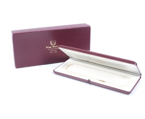 A cultured-pearl single row necklace on a 9ct gold clasp. The 63 uniform 5.5-5.75mm diameter cultured-pearls, knotted on an o