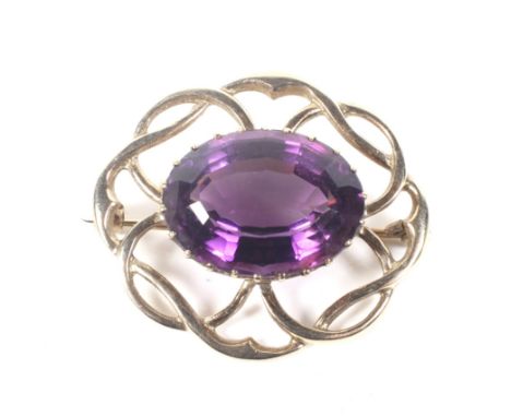 A vintage 9ct gold and oval amethyst brooch. Centred with an oval mixed-cut amethyst, approx. 18.78cts, claw set within an op