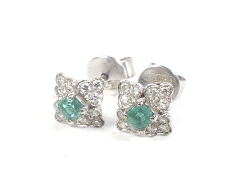 A pair of small small emerald and diamond flower-head quatrefoil cluster stud earrings. Each centred with a small, bright-gre