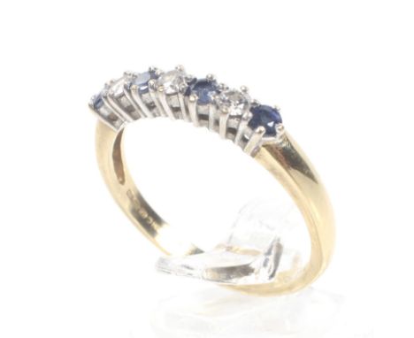 A modern 18ct gold, sapphire and diamond seven stone ring. The four bright blue small round mixed-cut sapphires spaced by sma