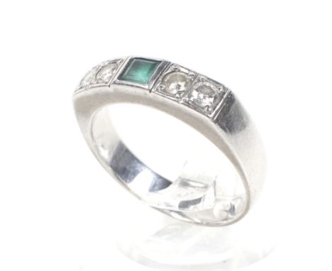 A modern emerald and diamond five stone ring. Centred with a square step-cut emerald, approx. 4.3mm, between pairs of round b