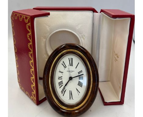 A Cartier Paris travel alarm clock in original red leather presentation case. 9cm x 7cm. 