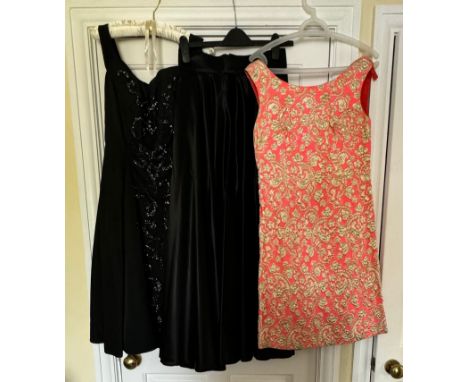 Three items of vintage clothing, a 1950's black sequin and beaded dress, an orange and gold 60's dress and a long full black 