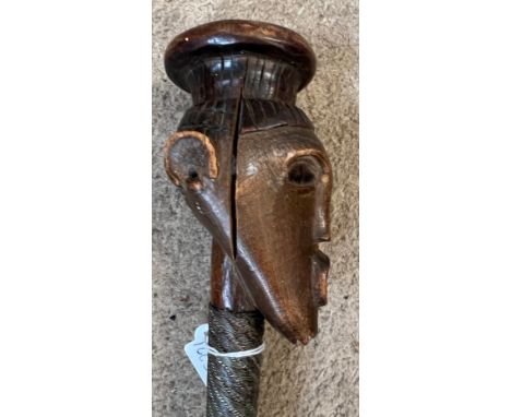 An African stick with carved head and metal covered shaft, circa 1940’s, brought back to England during WWII. 88cm h.