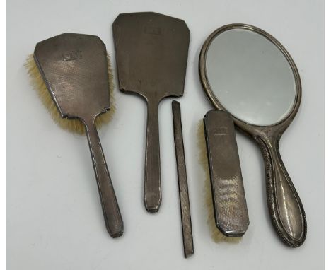 Silver mounted vanity set to include mirror, 2 x brushes and a comb holder with machine turned pattern and the initials M. T.