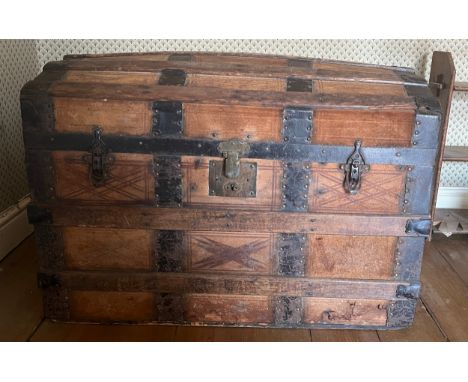 A dome topped leather covered trunk with metal and wooden binding. 76cm x 44cm x 52cm. 