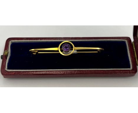 An 9 carat gold Art Deco target brooch set with a circular amethyst in a red leather silk lined presentation box. Length 4.5c