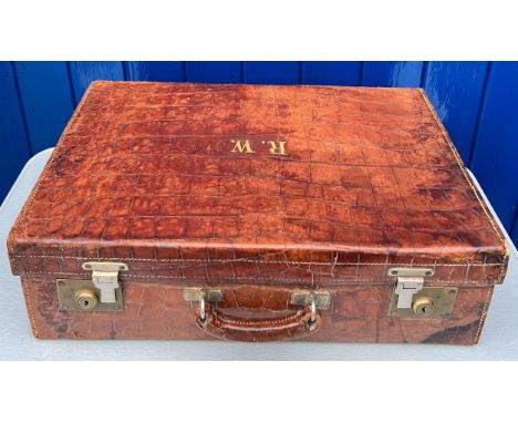 A vintage crocodile leather suitcase initialed R.W with brass fittings. Suitcase measures 56cm wide 37cm high 16.5cm deep. 