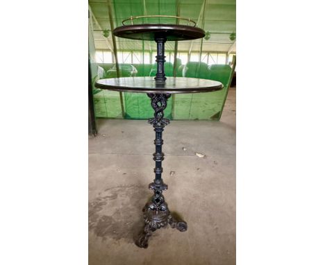 A vintage pub table with two tier wooden top and brass gallery  with heavy cast iron base with two fish to base. 136cm h x 70