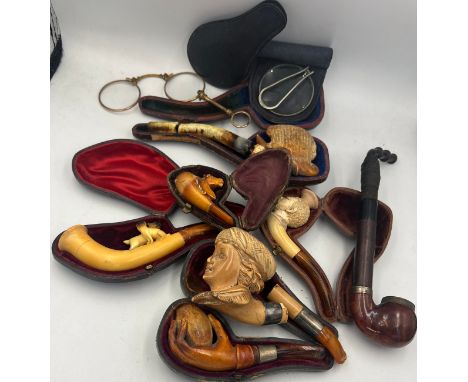 A quantity of carved Meerschaum pipes, lorgnette and a magnifying glass. 