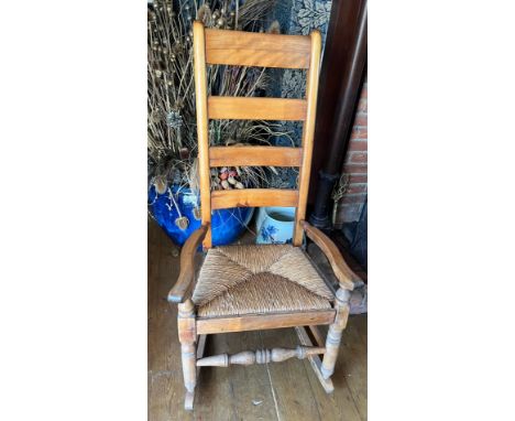 A rush seated ladder back rocking chair. 