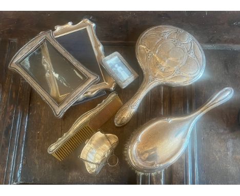 A quantity of silver to include three frames, mirror, hairbrush, comb and finger purse. Various dates and makers. 