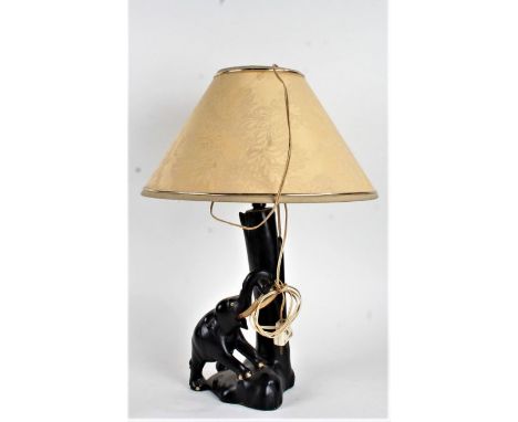 20th Century ebonised reading lamp, formed as an elephant besides a tree trunk, 49cm high
