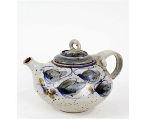 Art pottery teapot, the loop handle above a foliate decorated boy, stamped indistinctly to foot, 21cm wide, 13cm high