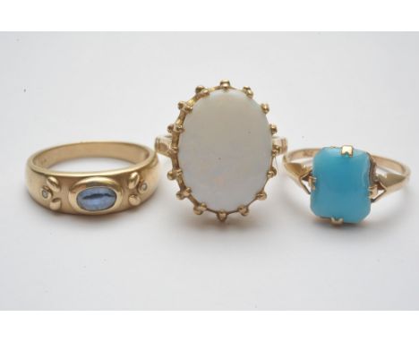 A collection of three 9ct gold rings each set with a single stone cabochon comprising sapphire, opal and turquoise coloured g