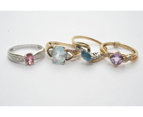 A collection of four 9ct gold dress rings set with coloured stones including topaz and fancy cut amethyst with diamond set mo