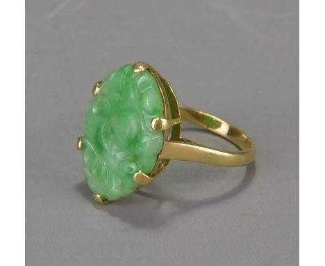 A carved jade stone mounted in 18k gold ring 