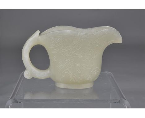 A Chinese white jade wine cup with handle. 9cm tall