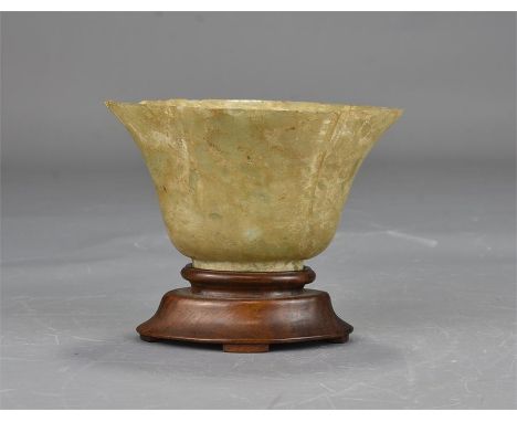 A Chinese jade cup on a bow-wood stand. 10cm tall 