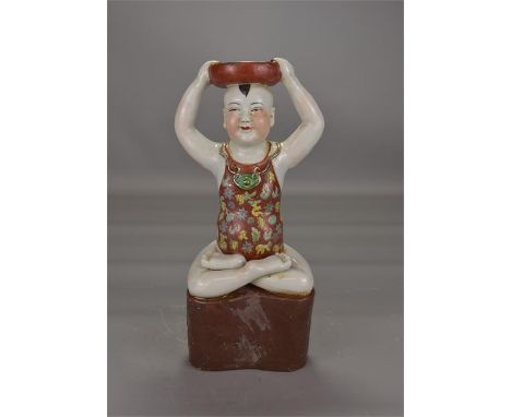 A 20th century Chinese oil lamp in the form of a young boy. 26cm tall