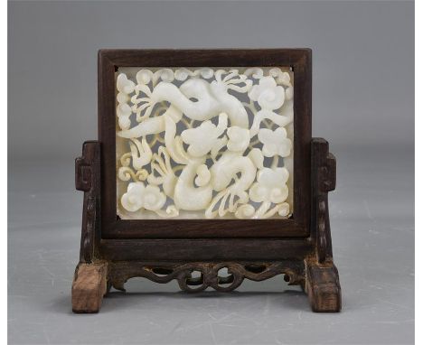 A19th century carved white jade plaque fitted into a possibly later wooden stand. 12cm x 13cm 