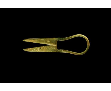 1st-3rd century AD. A pair of bronze shears with round-section bar handle; straight edged blades tapering to a point.  39 gra