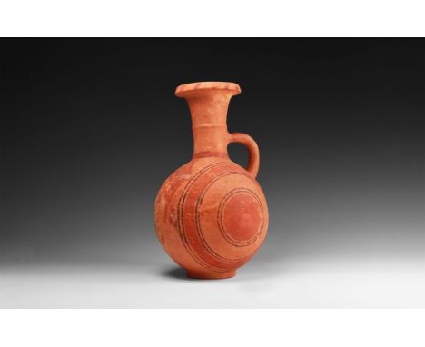 12th-10th century BC. A terracotta globular jug with basal ring, trumpet-shaped neck with median fillet, everted and chamfere