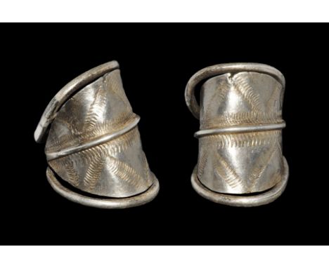 10th-12th century AD. A sheet silver finger ring with median hoop extending to two round-section bars coiled to the edges of 