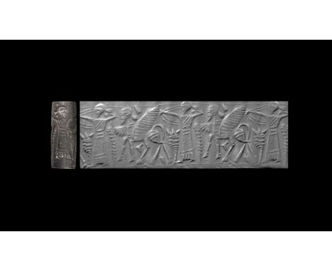 8th-6th century BC. A haematite cylinder seal with a winged bull standing facing left, away from a standing archer who wears 