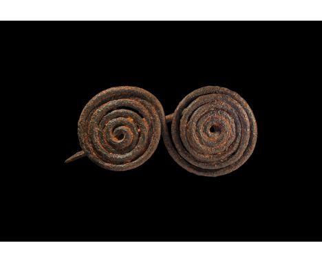 1st millennium BC. A substantial iron spectacle brooch formed as a double coil with integral catch and pin.  131 grams, 13cm 