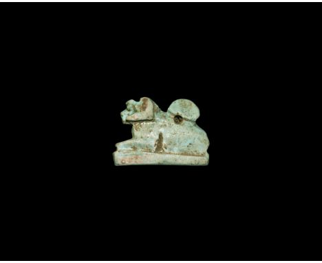 Saite Period, 624-525 BC. A pale blue glazed composition amulet of a ram crouching on a rectangular base. Cf. Andrews, C. Amu