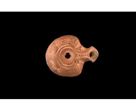 3rd - 4th Century AD. A small terracotta lamp, D-shaped in plan with short chamfered nozzle, band of geometric ornament to th