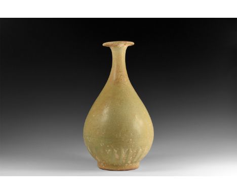 Song Dynasty, 960-1127 AD. A ceramic piriform bottle with trumpet-shaped mouth and basal ring, ribbed lower body; light olive