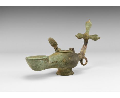 5th-7th century AD. A hollow-formed bronze slipper-shaped lamp with flared base, broad nozzle with annular socket, filler hol