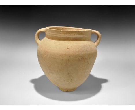 6th-8th century AD. A wheel-thrown terracotta vessel with basal ring, steep shoulder, broad rim, two lateral ribbed strap han