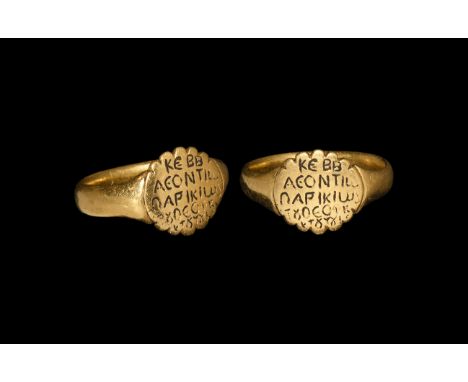 10th-12th century AD. A gold finger ring comprising a lentoid-section hoop, discoid bezel with dentilled edge, enigmatic Gree