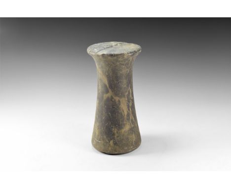 2nd millennium BC. A variegated limestone columnar idol, slightly waisted with shallow slot to each flat face. See Linenthal,