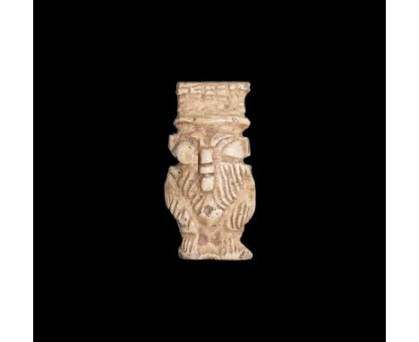 Late Period, 664-332 BC. A white glazed composition amulet of Bes standing nude with feathered headdress, tail to the reverse
