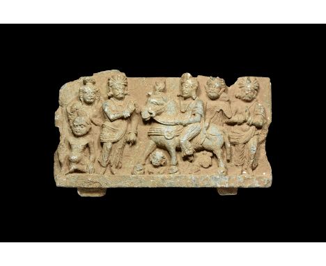 2nd-3rd century AD. A schist panel with the Buddha in royal robes, jewels and turban on a horse leaving the palace, to either