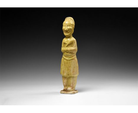 Song Dynasty, 960-1127 AD. A cream-glazed hollow-formed ceramic figurine of a standing figure with hands folded across the mi