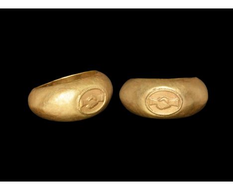 1st century AD. A hollow-formed gold D-section hoop with flared shoulders, rounded plaque, inset gold elliptical bezel with r