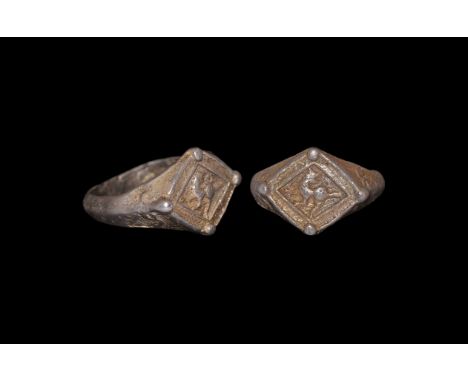 13th-16th century AD. A silver-gilt ring with D-section hoop widening to the shoulder with raised floral decoration; lozenge 