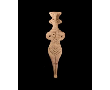 12th-7th century BC. A ceramic female figure with elaborate headdress, pinched facial features, applied necklace band, arms s